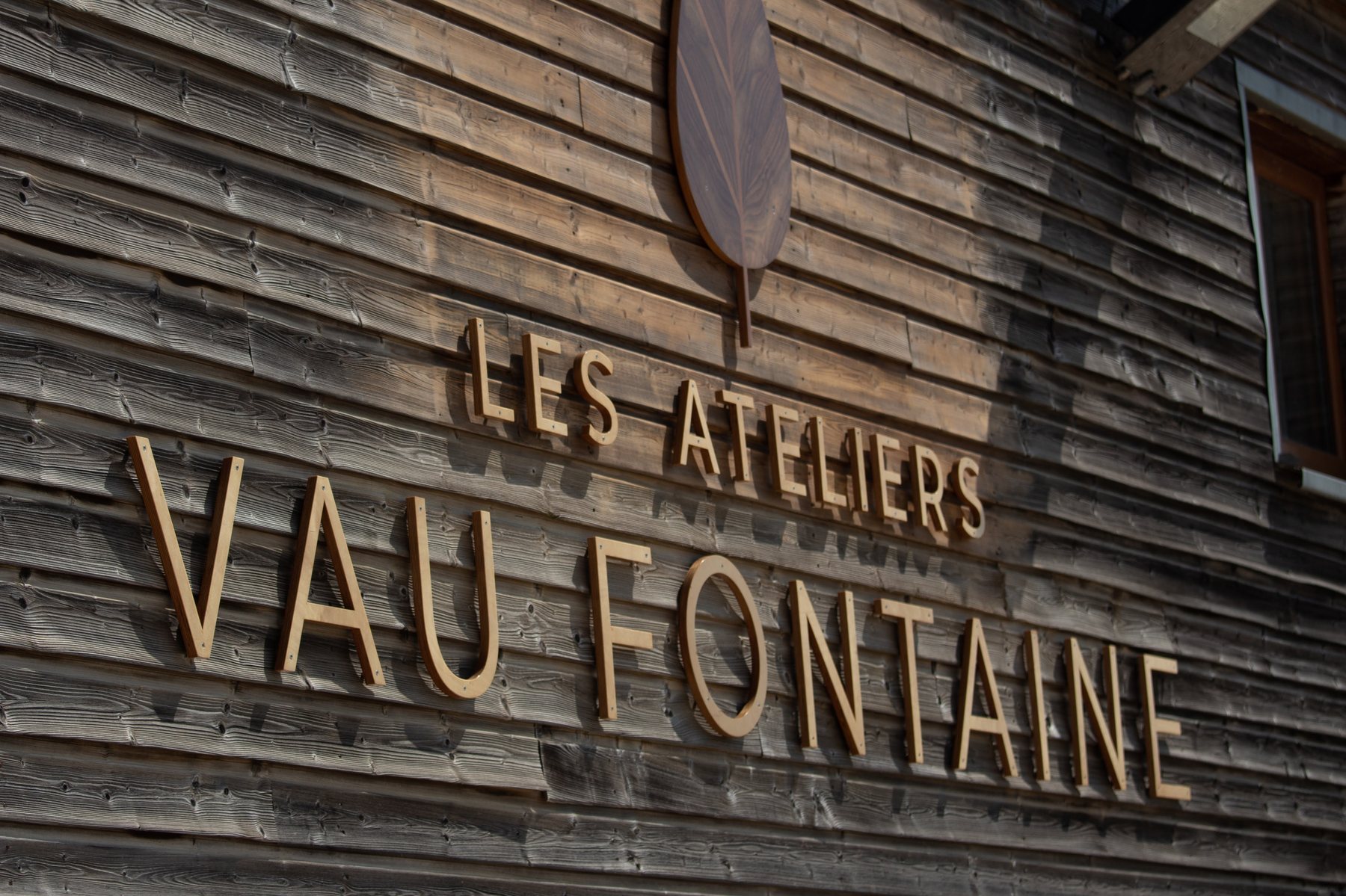 Façade de l'Atelier de Fabrication, enseigne en bois et feuille de noyer